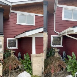 Picture of a red house with new gutter installation in white color.